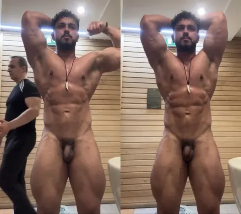 Muscular Bodybuilder Strips in Locker Room