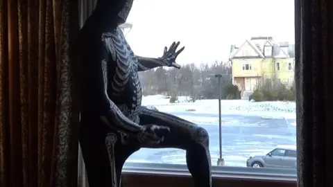 Morphsuit Guy Cums in Black Rubber Cock Extender