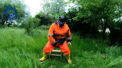 Gay Guy Rides Dino Toy in Garden Wearing HiVis