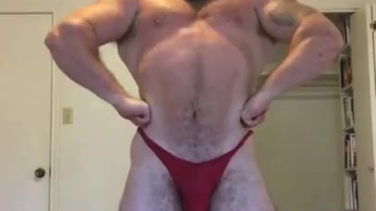 Muscular Bodybuilder Flexes in Revealing Trunks